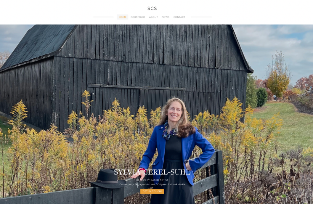 Screenshot of homepage for portfolio of Kentucky-based artist, Sylvia Cerel-Suhl. The main image shows a woman standing in front of a barn surrounded by fall foliage. 